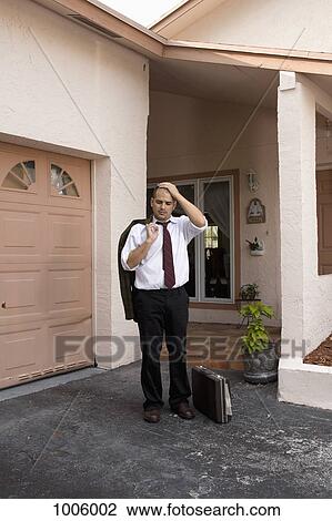 A businessman standing in his driving looking depressed View Large Photo Image Stock Image - A businessman standing in his driving looking depressed. Fotosearch