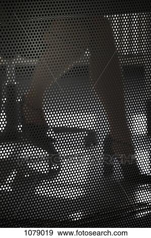 A businesswoman working at a desk, close-up of legs behind wire mesh screen View Large Photo Image Stock Photo - A businesswoman working at a desk, close-up of legs behind wire mesh screen. Fotosearch
