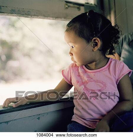 Picture - A child sitting on her mother's lap riding on a train. Fotosearch