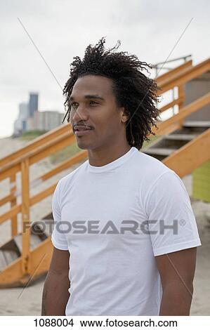 A cool young man at the beach looking at the view View Large Photo Image Picture - A cool young man at the beach looking at the view. Fotosearch