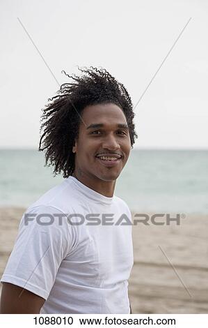 A cool young man standing on a windy beach, waist up View Large Photo Image Stock Image - A cool young man standing on a windy beach, waist up. Fotosearch