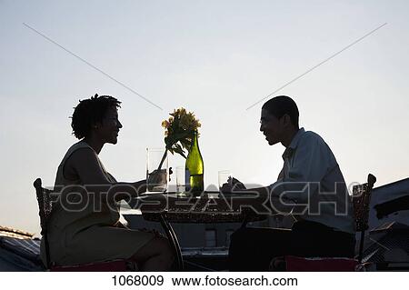 A couple dining on a rooftop terrace at sunset View Large Photo Image Stock Photo - A couple dining on a rooftop terrace at sunset. Fotosearch