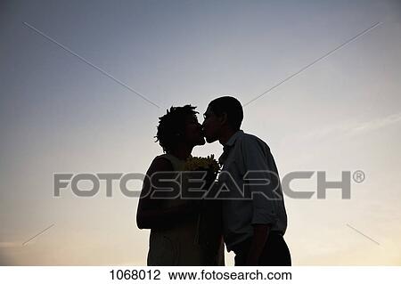 A couple kissing at sunset View Large Photo Image Stock Image - A couple kissing at sunset. Fotosearch