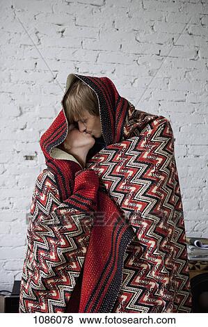 A couple kissing while wrapped in a blanket View Large Photo Image Stock Photo - A couple kissing while wrapped in a blanket. Fotosearch
