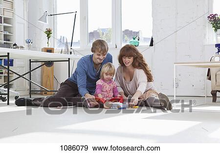 A family playing together on the floor View Large Photo Image Stock Photo - A family playing together on the floor. Fotosearch