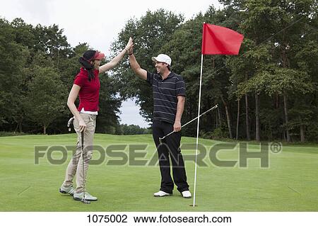 A female golfer high-fiving a male golfer on the putting green View Large Photo Image Stock Image - A female golfer high-fiving a male golfer on the putting green. Fotosearch