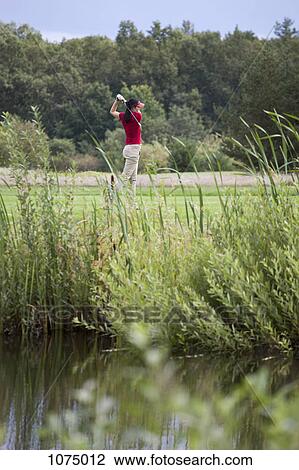 A female golfer teeing off View Large Photo Image Stock Image - A female golfer teeing off. Fotosearch