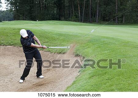 A golfer hitting a ball out of a sand trap View Large Photo Image Stock Photography - A golfer hitting a ball out of a sand trap. Fotosearch