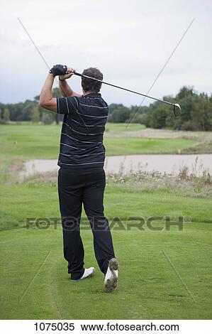 A golfer teeing off, rear view View Large Photo Image Stock Photography - A golfer teeing off, rear view. Fotosearch