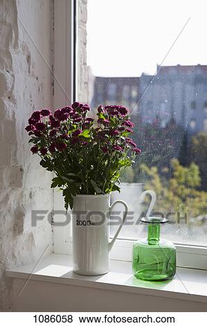 A green bottle and bouquet of flowers on a window sill View Large Photo Image Stock Photo - A green bottle and bouquet of flowers on a window sill. Fotosearch