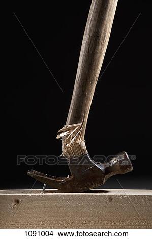 A hammer handle breaking while trying to remove a nail from a beam View Large Photo Image Picture - A hammer handle breaking while trying to remove a nail from a beam. Fotosearch