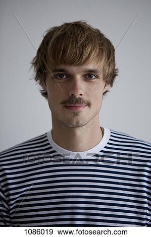 A hip young man wearing a striped t-shirt, looking at camera View Large Photo Image Stock Photo - A hip young man wearing a striped t-shirt, looking at camera. Fotosearch