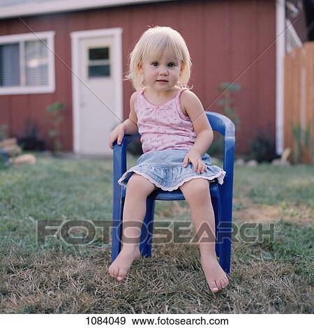 A little girl sitting on a plastic chair in a yard View Large Photo Image Stock Photo - A little girl sitting on a plastic chair in a yard. Fotosearch