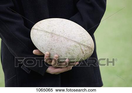 A man holding a rugby ball behind his back, close-up of hands View Large Photo Image Stock Photography - A man holding a rugby ball behind his back, close-up of hands. Fotosearch
