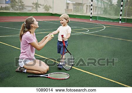 A mother and son having fun on tennis court View Large Photo Image Picture - A mother and son having fun on tennis court. Fotosearch
