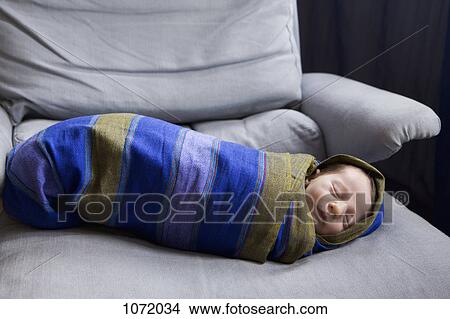 Picture - A newborn baby swaddled in a striped blanket. Fotosearch