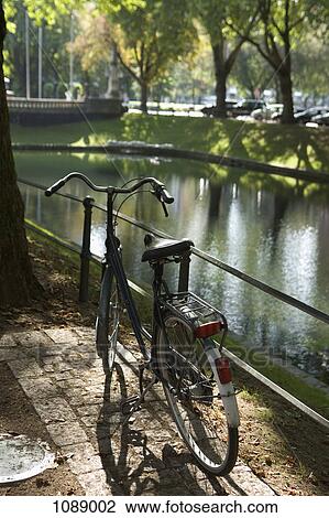 A old fashioned bicycle parked next to a river View Large Photo Image Stock Image - A old fashioned bicycle parked next to a river. Fotosearch