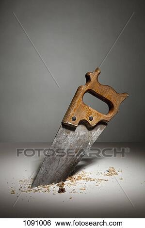 A saw sawing through wood View Large Photo Image Stock Photograph - A saw sawing through wood. Fotosearch