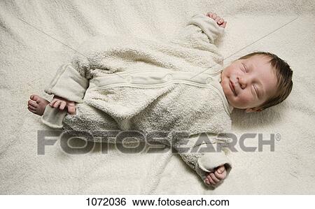A sleeping newborn with her arms stretched out View Large Photo Image Stock Photograph - A sleeping newborn with her arms stretched out. Fotosearch