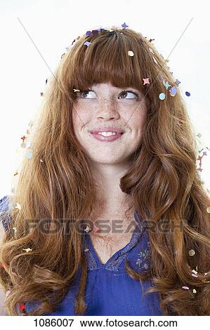 Stock Photo - A smiling young woman with confetti in her hair. Fotosearch