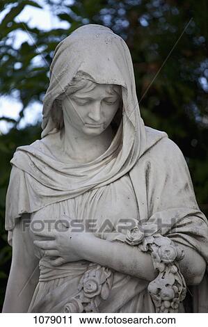 A statue of a robed woman holding a wreath View Large Photo Image Stock Image - A statue of a robed woman holding a wreath. Fotosearch