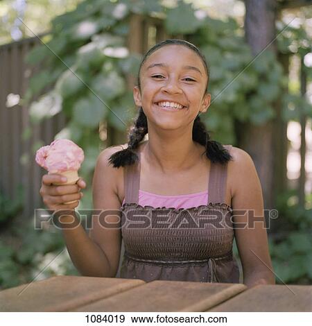 Stock Photo - A teenage girl holding an ice cream cone. Fotosearch