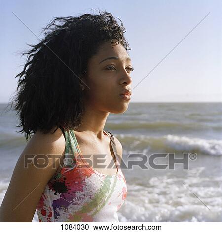 A teenage girl looking at view, water in background View Large Photo Image Stock Image - A teenage girl looking at view, water in background. Fotosearch