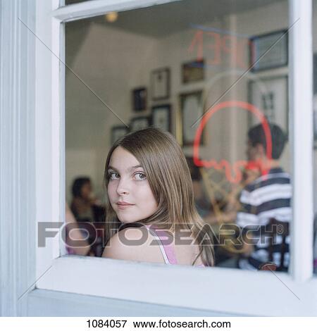 A teenage girl looking through a cafe window View Large Photo Image Stock Photo - A teenage girl looking through a cafe window. Fotosearch