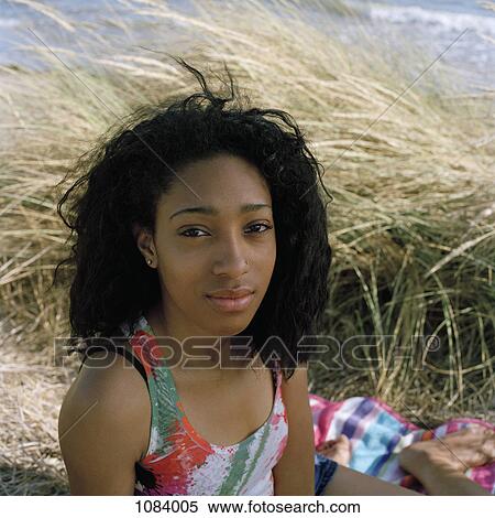 A teenage girl sitting on the beach, looking at camera View Large Photo Image Stock Photography - A teenage girl sitting on the beach, looking at camera. Fotosearch