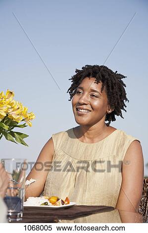 A woman eating a meal on a rooftop terrace View Large Photo Image Stock Photography - A woman eating a meal on a rooftop terrace. Fotosearch