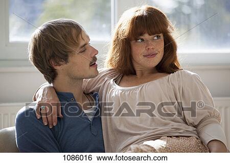 Stock Photograph - A woman looking away playfully while her boyfriend talks to her. Fotosearch