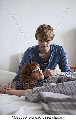 Stock Image - A woman lying in her boyfriend's lap looking at camera sensually. Fotosearch