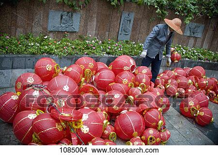 A worker considering a pile of Chinese lanterns View Large Photo Image Picture - A worker considering a pile of Chinese lanterns. Fotosearch