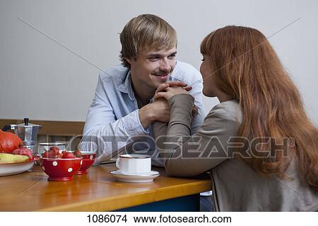 A young affectionate couple having breakfast View Large Photo Image Picture - A young affectionate couple having breakfast. Fotosearch