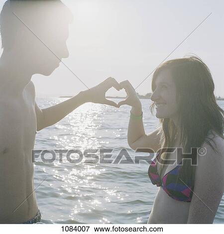 A young couple making a heart sign with their hands View Large Photo Image Stock Photo - A young couple making a heart sign with their hands. Fotosearch