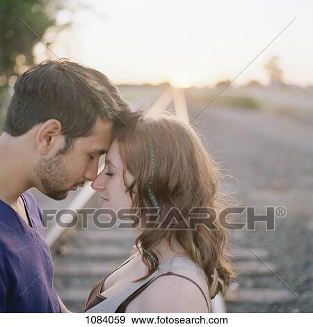 A young couple touching foreheads near railroad track View Large Photo Image Stock Photo - A young couple touching foreheads near railroad track. Fotosearch