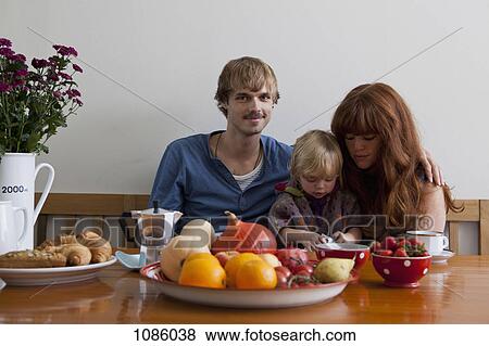 Stock Photo - A young family having breakfast together. Fotosearch