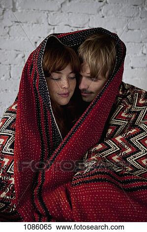 A young serene couple wrapped in a blanket View Large Photo Image Stock Photography - A young serene couple wrapped in a blanket. Fotosearch