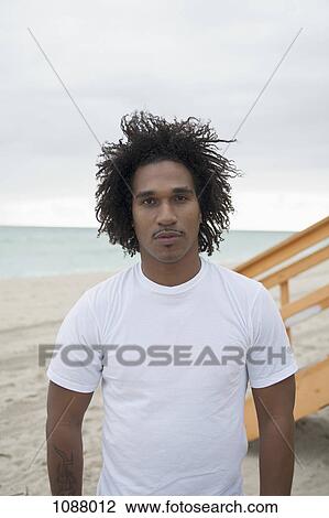 A young serious man at the beach, front view, waist up View Large Photo Image Stock Image - A young serious man at the beach, front view, waist up. Fotosearch