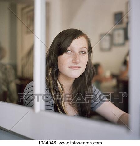 A young woman looking through a window in contemplation View Large Photo Image Stock Photograph - A young woman looking through a window in contemplation. Fotosearch