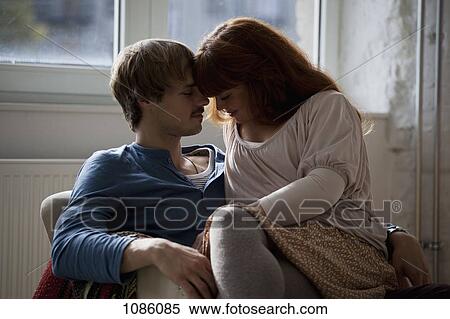 A young woman sitting on her boyfriend's lap View Large Photo Image Stock Photography - A young woman sitting on her boyfriend's lap. Fotosearch