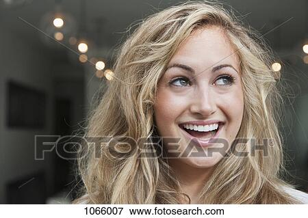 Stock Photo - A young woman smiling and looking up. Fotosearch