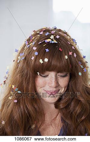 Stock Photo - A young woman with confetti in her hair. Fotosearch
