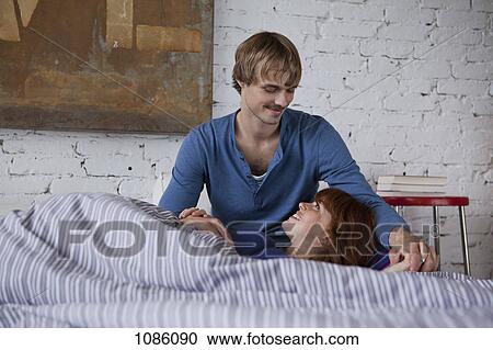 Stock Image - A young woman with her head in her boyfriend's lap. Fotosearch