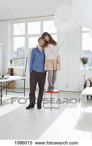 A young women standing on a stool next to her tall boyfriend View Large Photo Image Stock Photography - A young women standing on a stool next to her tall boyfriend. Fotosearch
