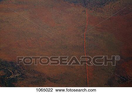 Aerial view of a dirt road positioned in a remote landscape View Large Photo Image Stock Image - Aerial view of a dirt road positioned in a remote landscape. Fotosearch
