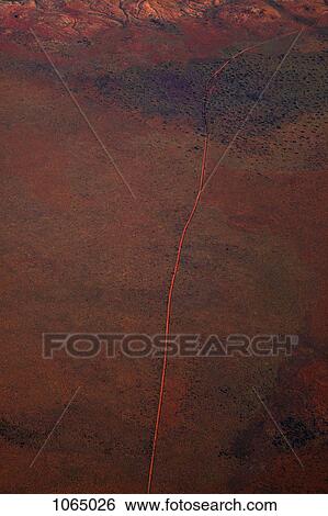 Aerial view of a dirt road positioned in a remote landscape View Large Photo Image Stock Photograph - Aerial view of a dirt road positioned in a remote landscape. Fotosearch