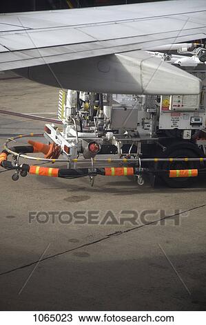 Stock Image - Airplane wing and airport land vehicle. Fotosearch
