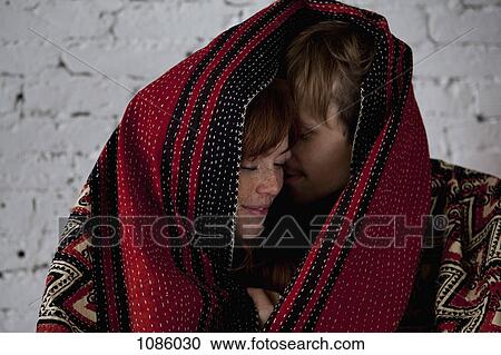 An affectionate couple wrapped in a blanket View Large Photo Image Stock Image - An affectionate couple wrapped in a blanket. Fotosearch