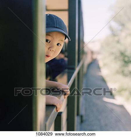 Stock Photo - An excited boy leaning out of a train window. Fotosearch